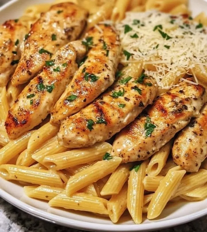 Creamy Parmesan chicken served with penne pasta on a plate