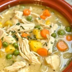 Delicious creamy soup served in a bowl with fresh herbs on top.