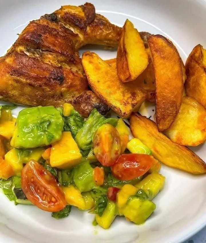 Grilled chicken quarters with crispy wedges and tropical avocado-mango salad