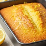 Delicious lemon sponge cake on a white plate garnished with lemon slices