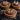 Delicious mini chocolate hazelnut tartlets served on a decorative plate.