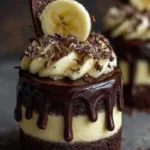 Mini chocolate banana mousse cakes topped with chocolate drizzle and banana slices