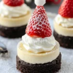 Mini Santa Hat Cheesecakes topped with whipped cream and strawberry decoration
