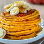 Fluffy pumpkin pancakes stacked with maple syrup and fall spices
