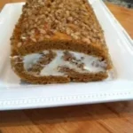 Homemade Pumpkin Roll Cake with cream cheese filling on a serving plate.