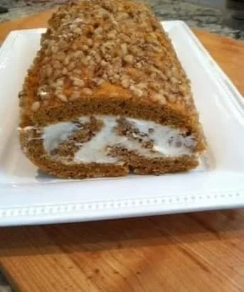 Homemade Pumpkin Roll Cake with cream cheese filling on a serving plate.