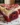 Red velvet cinnamon rolls with cream cheese glaze on a plate