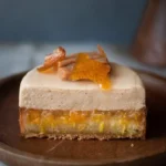 Delicious sweet orange-cinnamon square dessert on a white plate