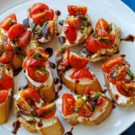 Delicious Tomato Goat Cheese Crostini topped with fresh herbs and tomatoes